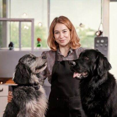 Une toiletteuse canine avec deux chiens